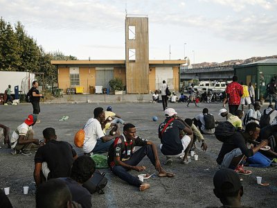 Des migrants reçoivent un repas préparé par des bénévoles, à Vintimille, en Italie près de la frontière française, le 9 août 2017 - Marco BERTORELLO [AFP]