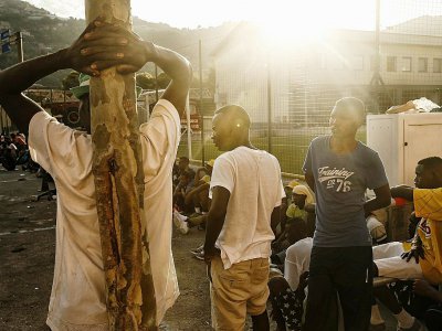 Des migrants font la queue pour recevoir un repas, dans un centre d'aide dans l'église Gianchette à Vintimille, le 9 août 2017 - Marco BERTORELLO [AFP]