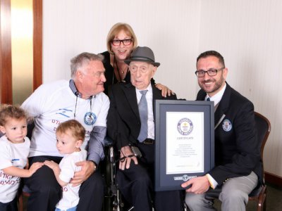 Yisrael Kristal (c) reçoit son certificat du Guinness des records l'identifiant comme l'homme le plus vieux du monde, sur une photo publiée le 11 mars 2016 - Dvir Rosen [AFP/Archives]