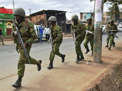 Des policiers courent pour disperser des manifestants dans le bidonville de Kibera, à Nairobi, le 12 août 2017 - CARL DE SOUZA [AFP]
