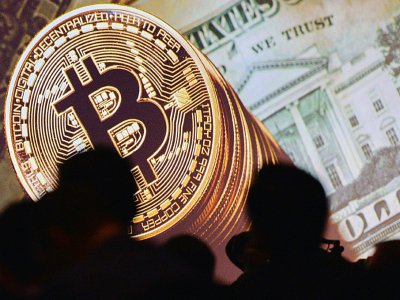 Les monnaies virtuelles comme le bitcoin ou encore l'ether ou le litecoin intéressent de plus en plus de particuliers.
Ci-contre image d'un bitcoin exposée lors du congrès mondial d'Interpol à Singapour, le 4 juillet 2017 - ROSLAN RAHMAN [AFP/Archives]