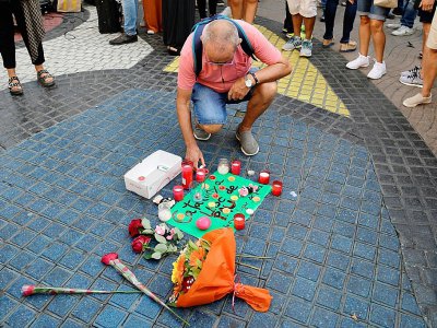 Des passants déposent des fleurs et des bougies sur la Rambla de Barcelone le 18 août 2017 en hommage aux victimes - JAVIER SORIANO [AFP]