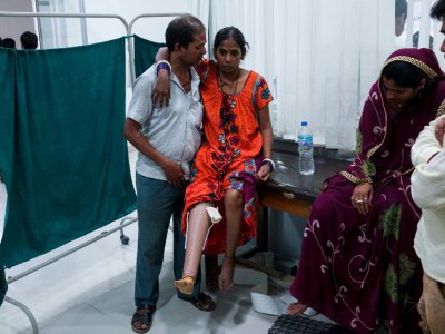 Un Indien aide son épouse à marcher avec une nouvelle prothèse à Jaipur, dans le nord de la l'Inde, le 13 juin 2017 - CHANDAN KHANNA [AFP]