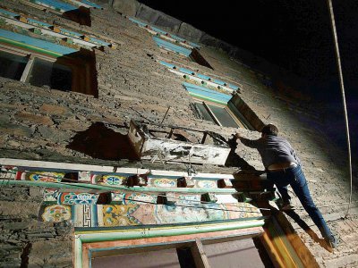 Trinley Norbu, un membre de l'éthnie tibétaine matriarcale des Zhaba, montre comment il grimpe aux murs de la maison de la femme qu'il convoite, le 27 mai 2017 dans la vallée du fleuve Yalong, dans la province chinoise du Sichuan - Johannes EISELE [AFP]