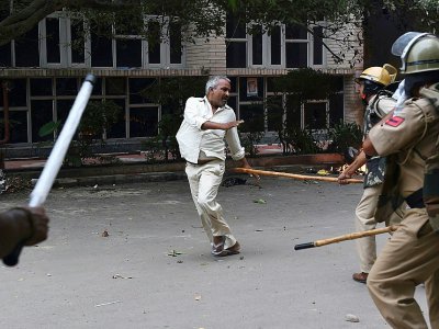 Un adepte de Gurmeet Ram Rahim Singh face aux forces de l'ordre indiennes lors de heurts après la condamnation pour viol du gourou, le 25 août 2017 à Panchkula - MONEY SHARMA [AFP]
