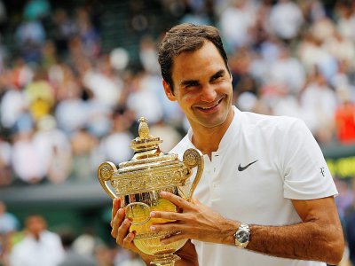 Le Suisse Roger Federer savoure sa victoire, trophée en main, face au Croate Marin Cilic en finale à Wimbledon, le 16 juillet 2017 - Adrian DENNIS [AFP]