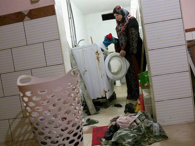 Une femme palestinienne met en marche la machine à laver quand revient le courant à Rafah, dans la bande de GAza, le 1er août 2017 - SAID KHATIB [AFP/Archives]