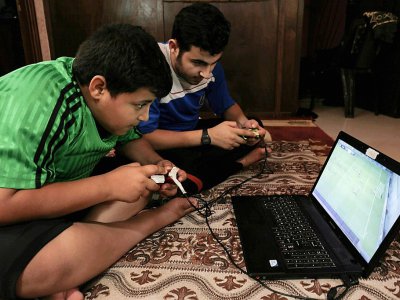 Des garçons palestiniens jouent sur l'ordinateur profitant de quelques heures d'électricité dans le camp de réfugiés à Rafah, dans la bande de Gaza, le 23 juillet 2017 - SAID KHATIB [AFP/Archives]