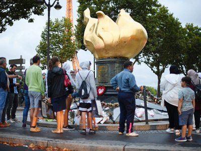 Plusieurs dizaines de bouquets de fleurs et de photographies de la princesse Diana ont été déposés au pied de la flamme du pont de l'Alma, réplique de la flamme de la Statue de la Liberté, à Paris le 30 août 2017 - Eric FEFERBERG [AFP]