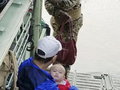Photo fournie par la marine américaine montrant un soldat intervenant pour sauver un adulte et un enfant à Galveston au Texas après le passage de la tempête Harvey, le 31 août 2018 - Handout [US Marine Forces Reserve/AFP]