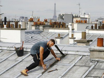 Un couvreur sur les toits de Paris, le 24 août 2017 - PATRICK KOVARIK [AFP]