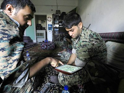 Des membres des Forces démocratiques syriennes (FDS) regardent un plan sur une tablette à l'intérieur d'un immeuble près de la Vieille ville de Raqa, le 3 septembre 2017 - Delil souleiman [AFP]