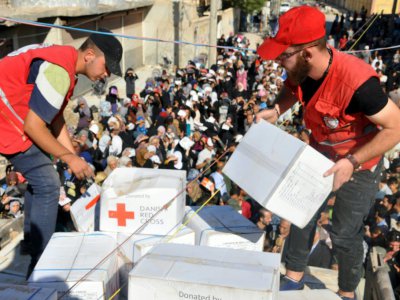 Des représentants du Croissant-Rouge syrien distribuent de l'aide alimentaire à Deir Ezzor, en Syrie, le 9 septembre 2017 - STRINGER [AFP]
