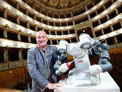 Le chef de l'orchestre philharmonique de Lucca, Andrea Colombini aux côtés de YuMi le robot, le 12 septembre 2017 à Pise - MIGUEL MEDINA [AFP]