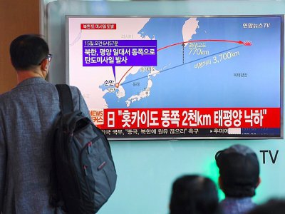 Des Sud-Coréens regardent sur un écran de télévision la trajectoire d'un nouveau tir de missile nord-coréen au-dessus du Japon, le 15 septembre 2017 dans une gare à Séoul - JUNG Yeon-Je [AFP]