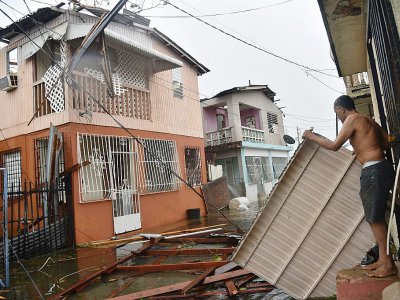 Des habitants de San Juan, à Porto Rico, examine les dégâts causés par l'ouragan Maria, le 20 septembre 2017 - Hector RETAMAL [AFP]