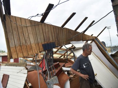 Un homme examine les restes de sa maison à Catano, à Porto Rico, le 21 septembre 2017 après le passage de l'ouragan Maria - HECTOR RETAMAL [AFP]