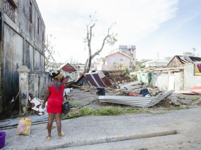 une femme observe les restes d'une maison à Roseau, capitale de la Dominique, le 21 septembre 2017 après le passage de l'ouragan Maria - Lionel CHAMOISEAU [AFP]