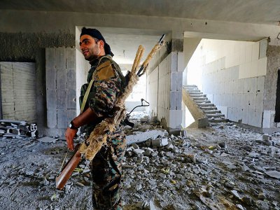 Un combattant des forces démocratiques syriennes (FDS) dans un immeuble détruit, le 21 septembre 2017 à Raqa - Delil souleiman [AFP]