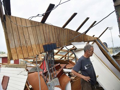 Un homme examine les restes de sa maison à Catano, à Porto Rico, le 21 septembre 2017 après le passage de l'ouragan Maria - HECTOR RETAMAL [AFP]