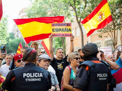Photo prise le 31 juillet 2017 de manifestants anti-indépendantistes à Barcelone brandissant des drapeaux espagnols et une pancarte avec pour slogan "Make Spain Great again" - Josep LAGO [AFP/Archives]