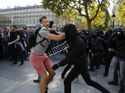 Un manifestant s'interpose face à un groupe de personnes cagoulées qui perturbent la manifestation de la France Insoumise contre les réformes du travail, Place de la République à Paris, le 23 septembre 2017 - Zakaria ABDELKAFI [AFP]