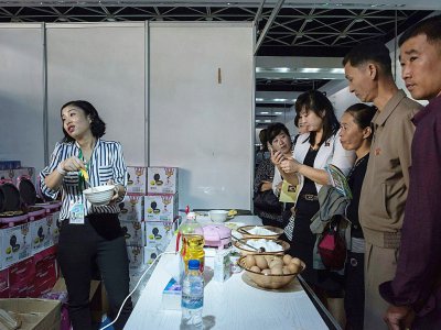 Une vendeuse présente un gaufrier à la Foire internationale à Pyongyang, le 25 septembre 2017 - Ed JONES [AFP]