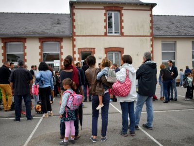 Des enfants et leurs parents devant une école primaire - LOIC VENANCE [AFP/Archives]