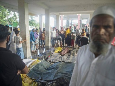Des Rohingyas se recueillent devant les corps de réfugiés morts dans un naufrage en venant chercher refuge au Bangladesh, le 29 septembre 2017 près de la plage d'Inani, à Cox's Bazar - FRED DUFOUR [AFP]