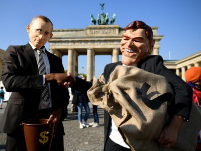 Des militants avec des masques de Poutine et Schröeder protestent devant la porte de Brandebourg à Berlin contre la nomination de l'ancien chancelier au conseil de surveillance du géant pétrolier Rosneft, le 29 septembre 2017 - Britta Pedersen [dpa/AFP]