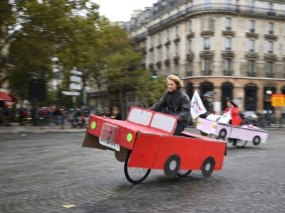 Des gens conduisent des vélos déguisés en voiture place de la Bastille à Paris lors de la journée sans voiture, le 1er octobre 2017 - ERIC FEFERBERG [AFP]