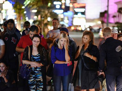 Des personnes se recueillent devant un mémorial près de l'hôtel Mandalay Bay après une fusillade meurtrière, le 3 octobre 2017 à Las Vegas - Robyn Beck [AFP]