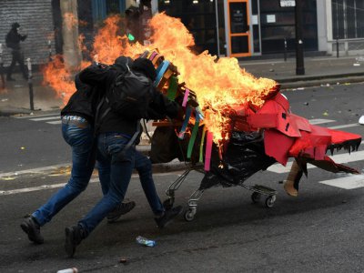 Des manifestants poussent un caddie en feu vers des CRS pendant une manifestation le 1er mai 2017 à Paris - Christophe ARCHAMBAULT [AFP/Archives]