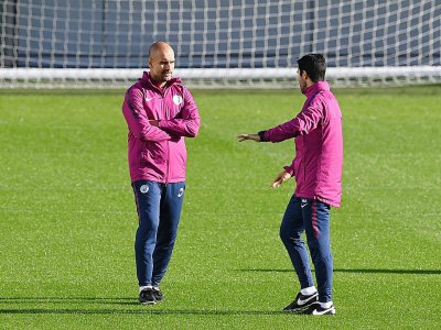 Le technicien de Manchester City Pep Guardiola (g) parle à son assistant Mikel Arteta lors d'une séance d'entraînement, le 16 octobre 2017 à Manchester - Paul ELLIS [AFP]