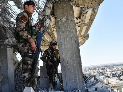 Des combattants des Forces démocratiques syriennes surveillent en haut d'un immeuble les positions des jihadistes de l'EI, prèsde l'hôpital de Raqa, le 16 octobre 2017 - BULENT KILIC [AFP]