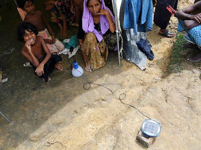 Des réfugiés Rohingyas attendent qu'une lanterne se charge grâce à l'énergie solaire, dans un camp de Kutupalong au Bangladesh, le 7 octobre 2017 - INDRANIL MUKHERJEE [AFP]
