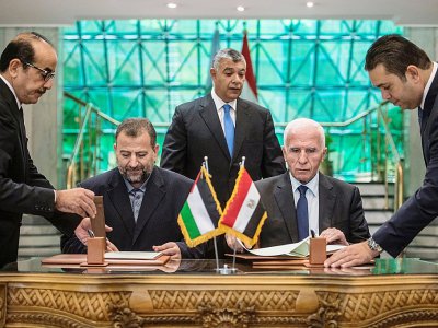 Azzam al-Ahmad (R) du Fatah et Saleh al-Arouri (L) du Hamas signent un accord de réconciliation au Caire le 12 octobre 2017 - KHALED DESOUKI [AFP/Archives]