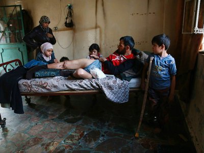 Photo prise le 23 octobre 2017 dans la région syrienne de la Ghouta orientale montrant un père, Abou Azzam, et son enfant de huit ans, tous deux handicapés à la suite d'un bombardement et dont la famille souffre de malnutrition - ABDULMONAM EASSA [AFP]