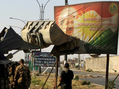 Des soldats irakiens détruisent un panneau à l'effigie de Massoud Barzani à Kirkouk le 16 octobre 2017 - AHMAD AL-RUBAYE [AFP/Archives]