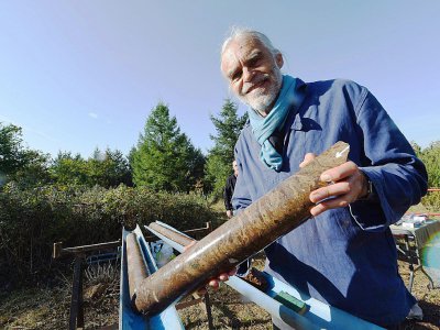 Philippe Lambert, astrogéologue, tient un échantillon de roche extrait d'un astroblème, ou "cicatrice d'étoile", le 17 octobre 2017 à Rochechouart, en Haute-Vienne - MEHDI FEDOUACH [AFP]