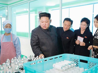 Photo du 29 octobre 2017 de l'agence de presse Nord coréenne (KCNA) montrant le leader nord-Coréen Kim Jong-Un (2eG) dans usine avec sa femme Ri Sol-Ju (D) - STR [KCNA VIA KNS/AFP]