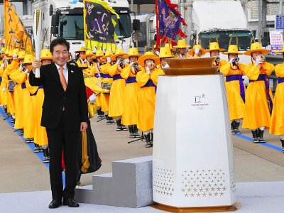 Le Premier ministre sud-coréen Lee Nak-Yon (d) portela flamme olympique, le 1er novembre 2017 à Séoul, lors d'une cérémonie pour son arrivée en Corée du Sud - JUNG Yeon-Je [AFP]