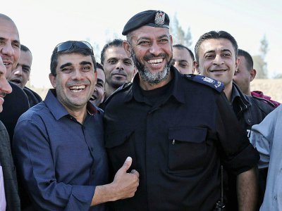 Un membre de l'Autorité palestinienne (G), sourit au côté d'un membre des forces de sécurité du Hamas, à Rafah, près de la frontière entre la bande de Gaza et l'Egypte, le 1er novembre 2017 - SAID KHATIB [AFP]