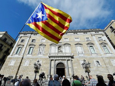 Une personne agite un drapeau pro-indépendance devant le siège du gouvernement catalan à Barcelone, le 30 octobre 2017 - LLUIS GENE [AFP/Archives]