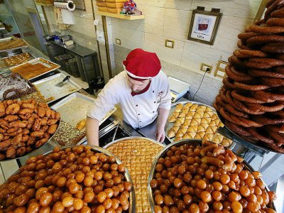 Des pâtisseries syriennes sont vendues dans la boutique de Mazen Obeido réfugié syrien dans sa boutique de Irbid (nord de la Jordanie), le 28 octobre 2017 - KHALIL MAZRAAWI [AFP]