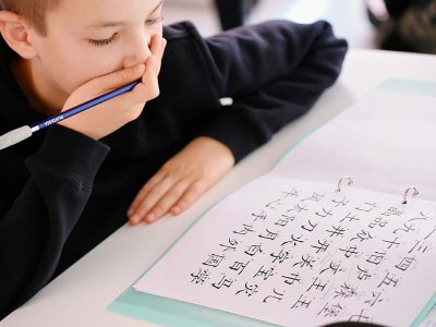Un élève luxembourgeois apprend la calligraphie chinoise, lors d'une leçon de chinois dans son établissement à Luxembourg, le 7 octobre 2017 - JOHN THYS [AFP]