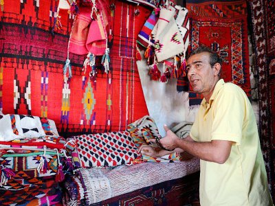 Un vendeur montre des tapis traditionnels dans son échoppe du marché de Hilla, le 12 octobre 2017 en Irak - SABAH ARAR [AFP]