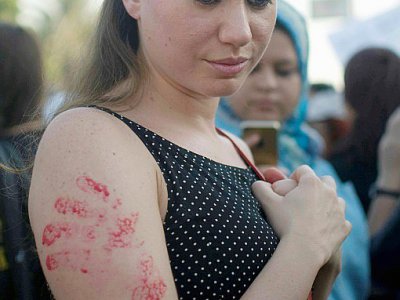 Photo d'une jeune femme arborant sur son bras des empreintes de main peintes en rouge, lors d'une manifestation contre le harcèlement sexuel le 14 juin 2014 au Caire - NAMEER GALAL [AFP/Archives]