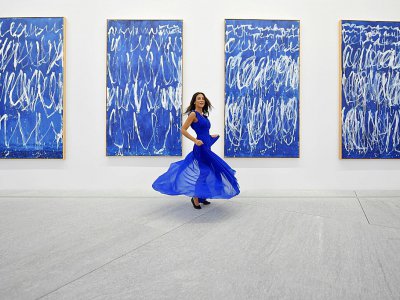 Une femme pose devant des tableaux du peintre américain Cy Twombly de la série "Untitled I-IX" au Louvre Abu Dhabi lors d'une visite organisée pour la presse le 6 novembre 2017 - GIUSEPPE CACACE [AFP]