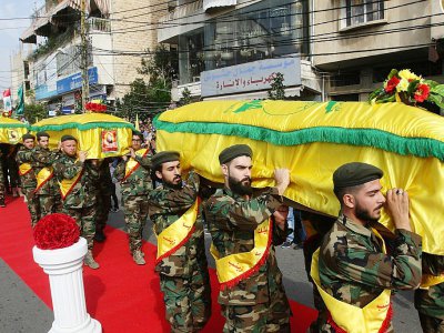 Des membres du Hezbollah portent les cercueils de trois de leurs camarades tués en Syrie en combattant au côté du régime, lors de funérailles à Nabatiyeh dans le sud du Liban le 8 novembre 2017 - Mahmoud ZAYYAT [AFP]